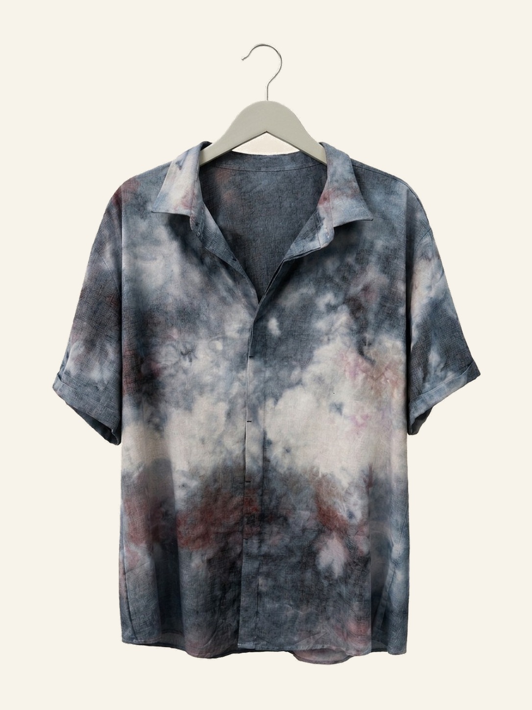 Hand ice-dyed cotton short-sleeve shirt in charcoal blue, cream, and dusty red on a pale grey hanger